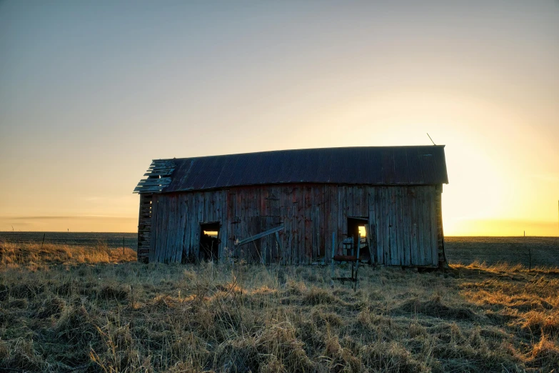 a old shed is standing out in a field