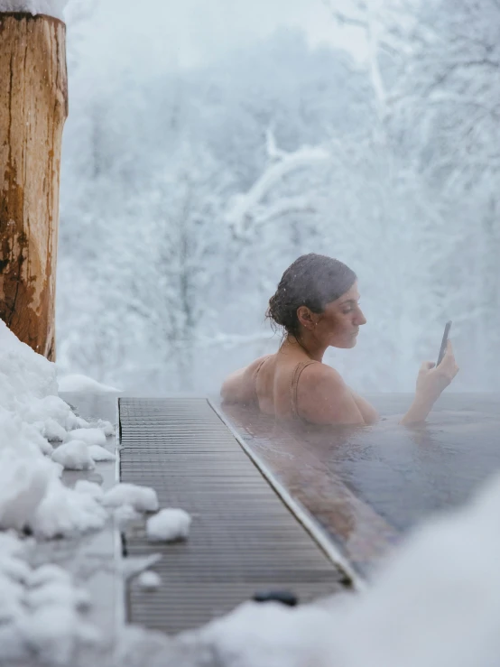 a person taking a picture while sitting in a  tub