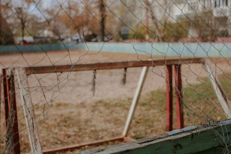 a broken fence and old building are in the background