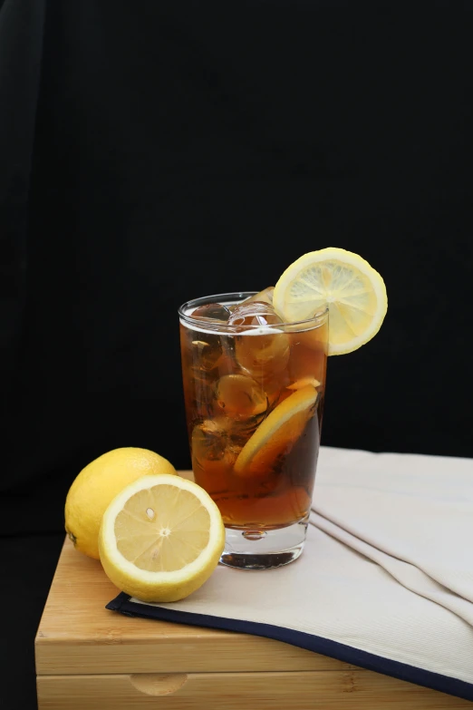 a drink with lemons sits on a wooden tray