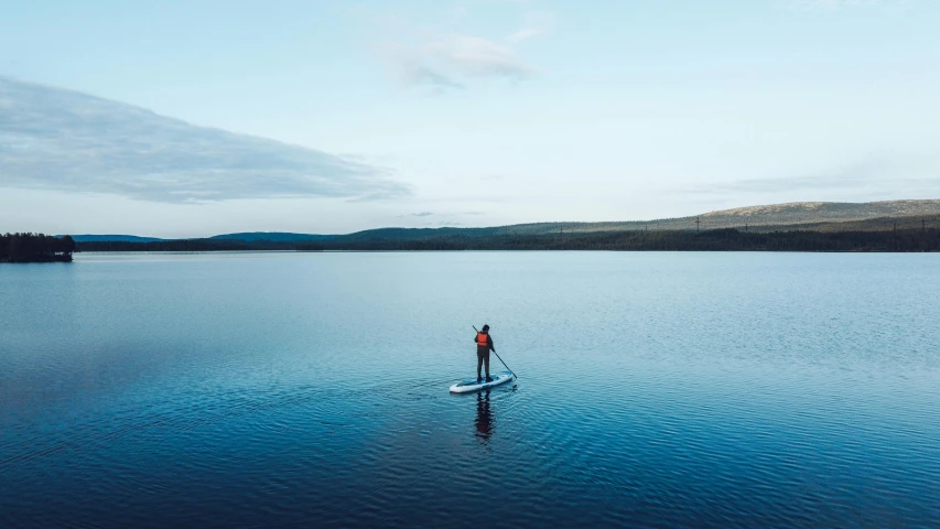 a man in red shirt on a paddle board