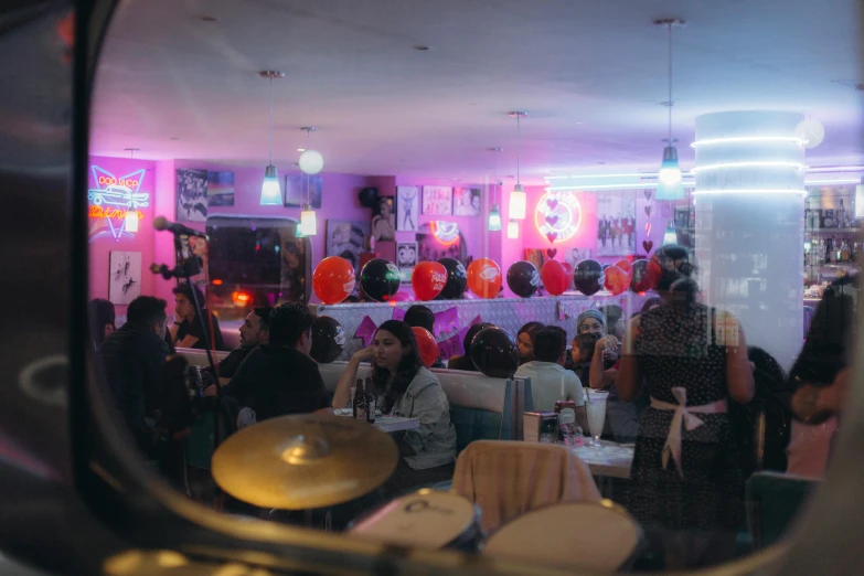 the group of people is gathered around the colorful room