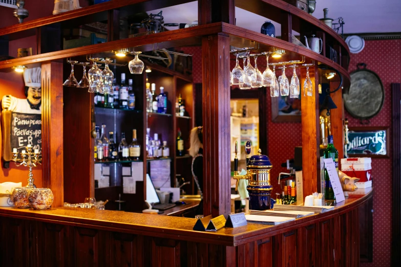 a small bar that has wine glasses on the shelves