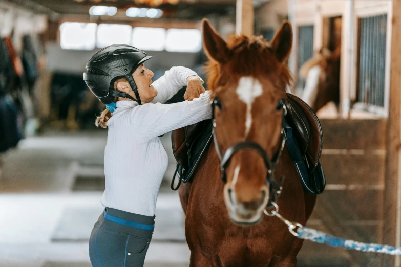 woman training a horse in an indoor stable