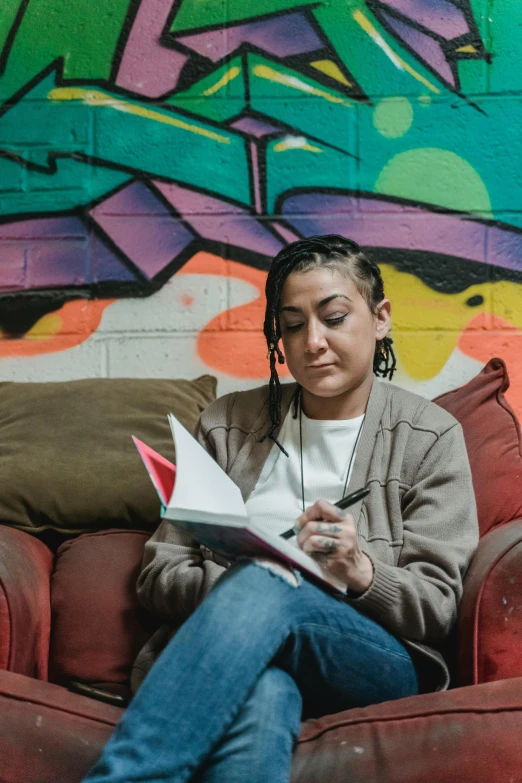 a woman sitting on a couch with a book