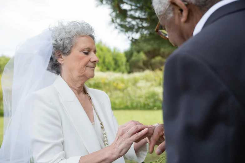 an elderly couple holds hands before they exchange their vows