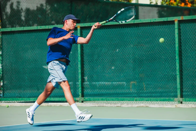 a man running while swinging a tennis racquet