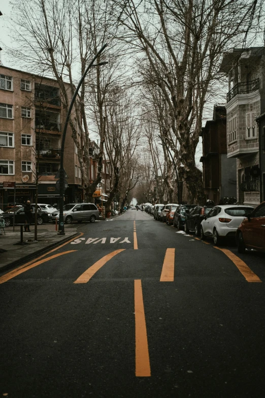 cars driving down the street beside a residential area