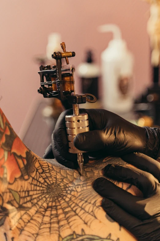 a tattoo artist prepares his tattoo on the back of his arm