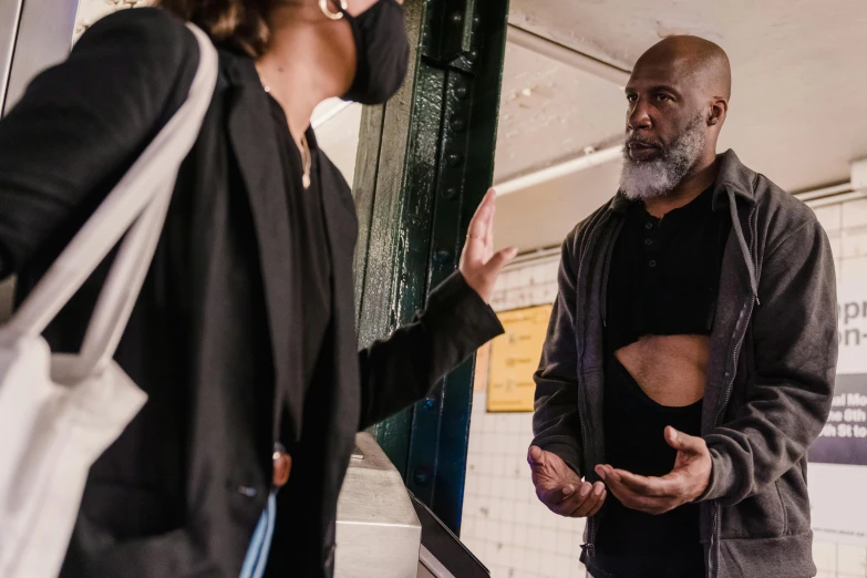 a man talking to another person at the train station