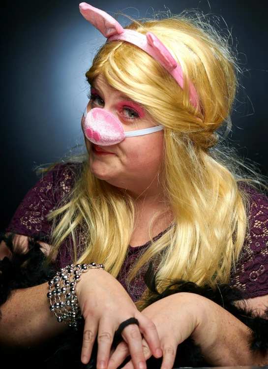 a woman in purple and a pink pig nose