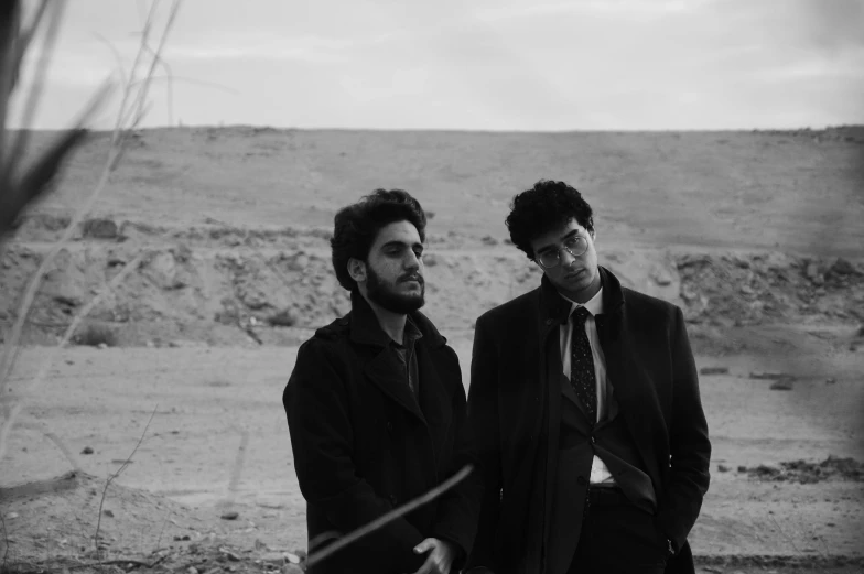 two men standing in a dirt area near each other