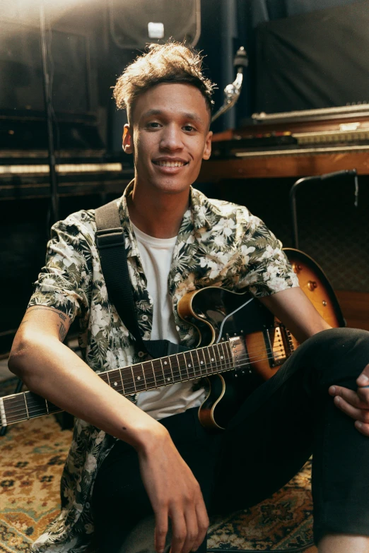 a person with a guitar sits near some lights