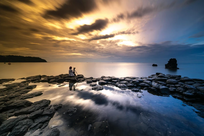 two people standing on top of a beach near the ocean