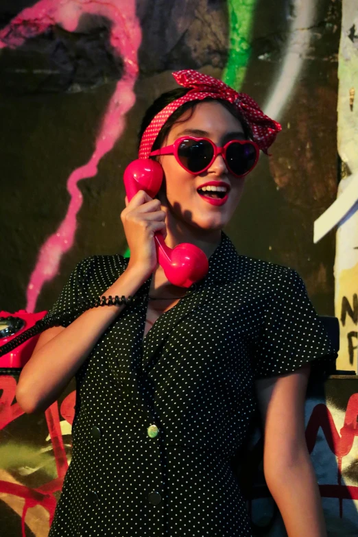 there is a woman in sunglasses and some pink telephones
