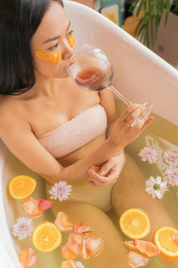a woman taking a bath with oranges and lemon slices on her face