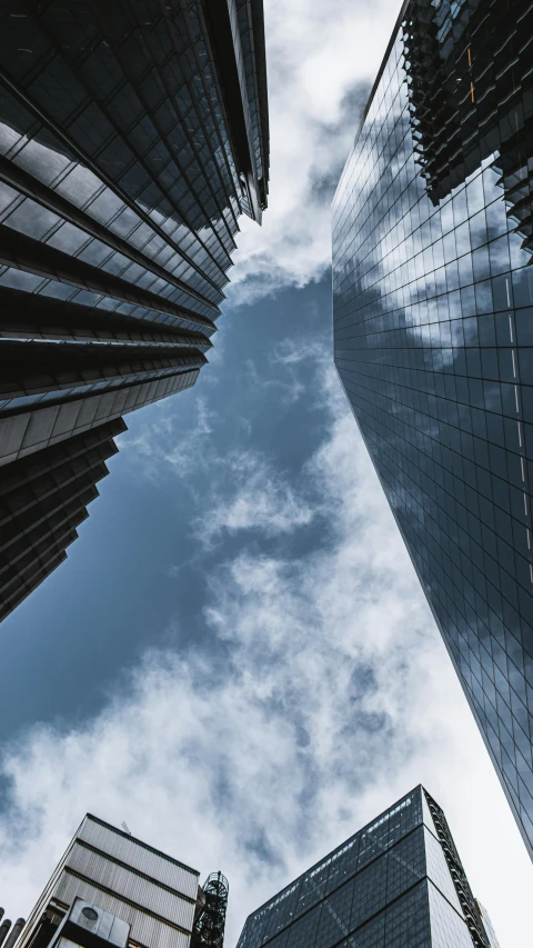 looking up at the tops of skyscrs in the city