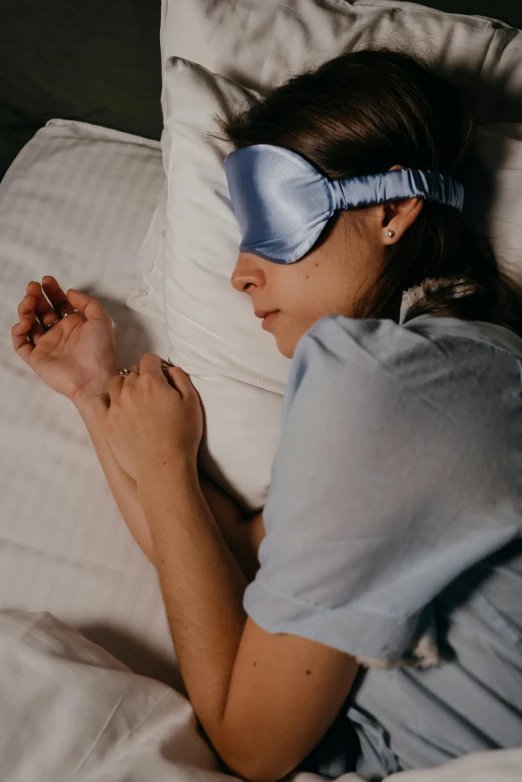 a woman is sleeping on her side with a blue pillow