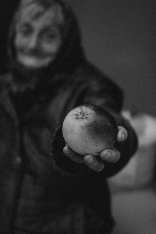 black and white pograph of someone holding an apple