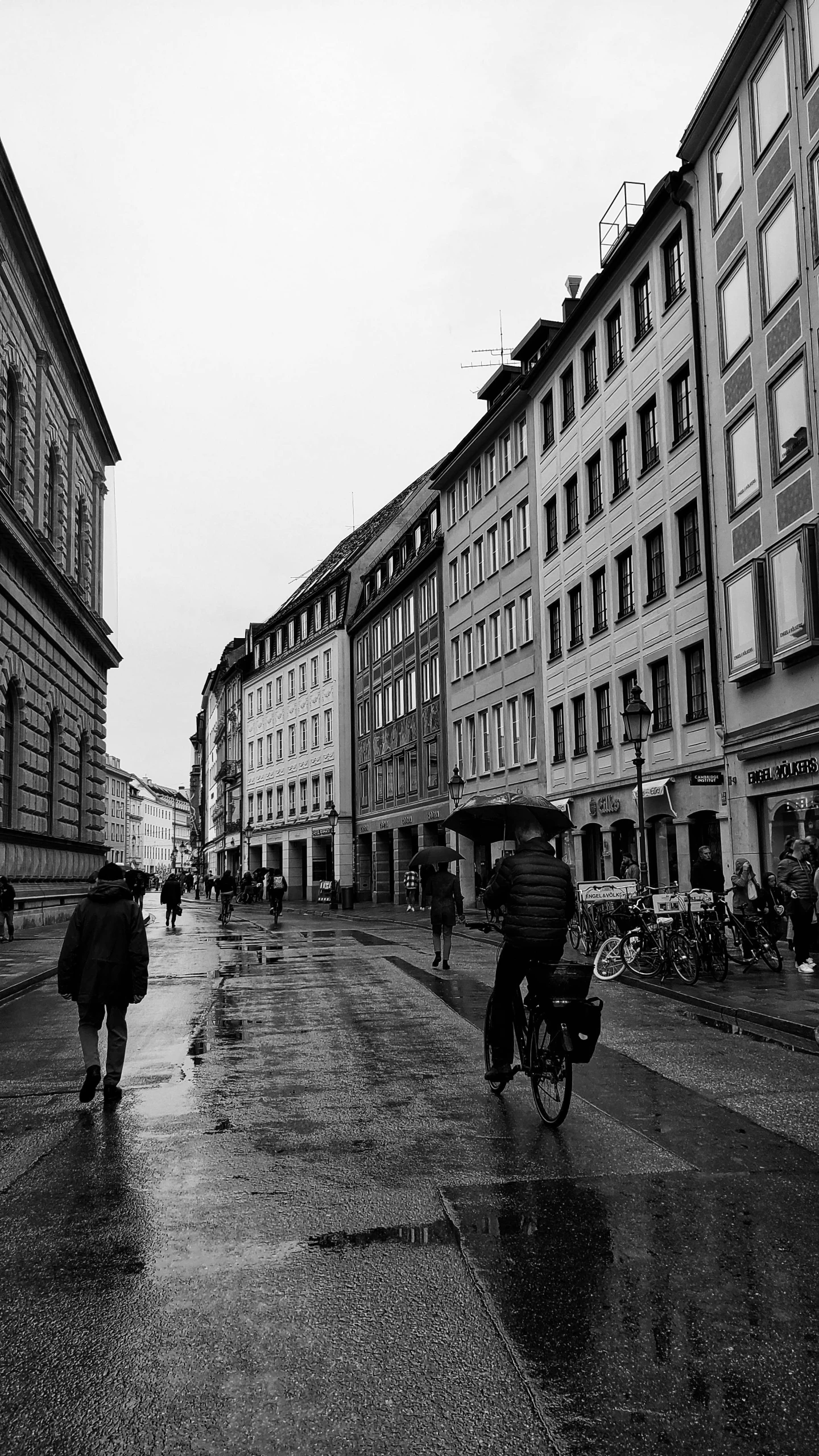 two people walking down a street while holding umbrellas