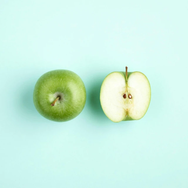 a green apple sitting in the middle of an apple slice