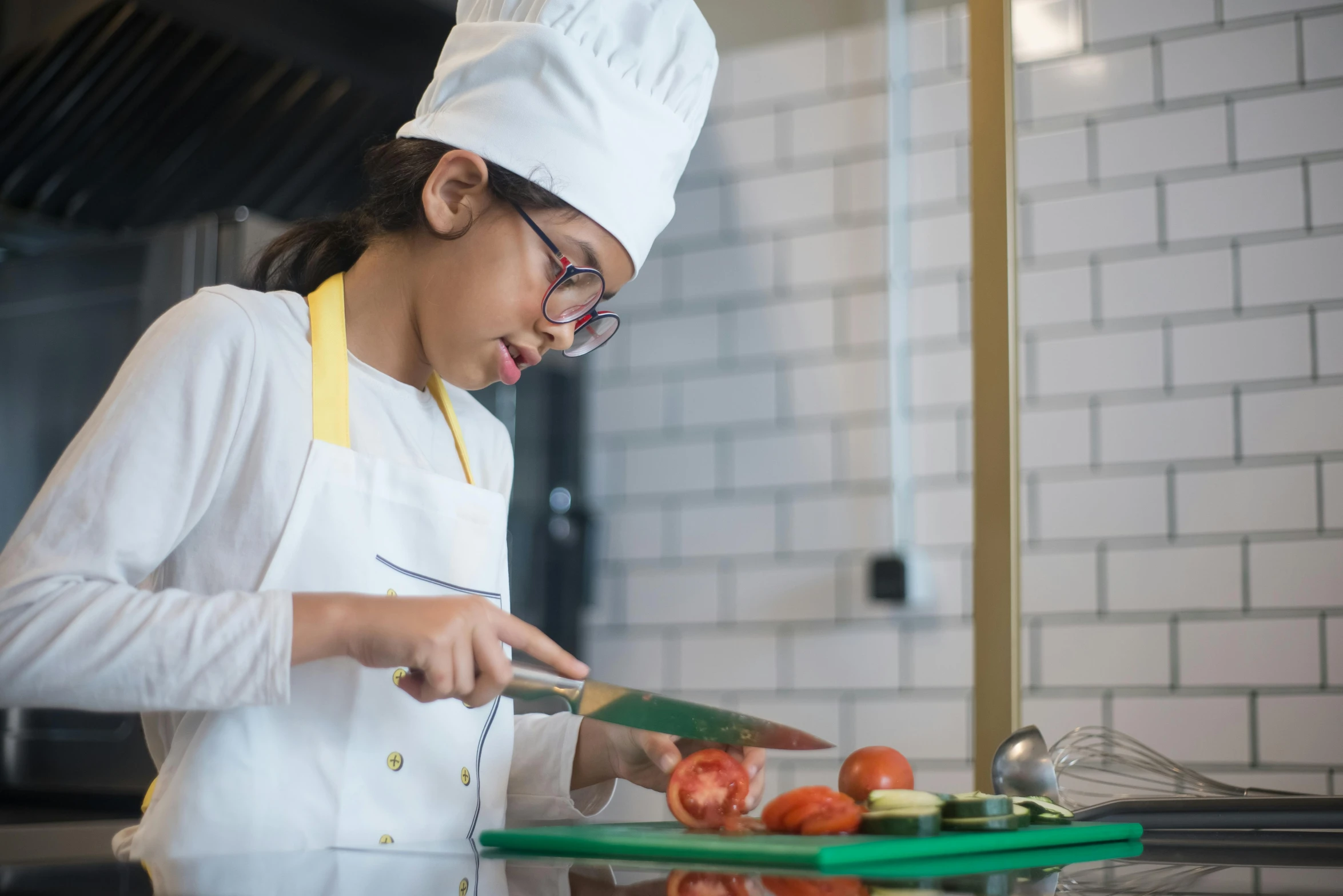 a woman in glasses and a hat preparing food