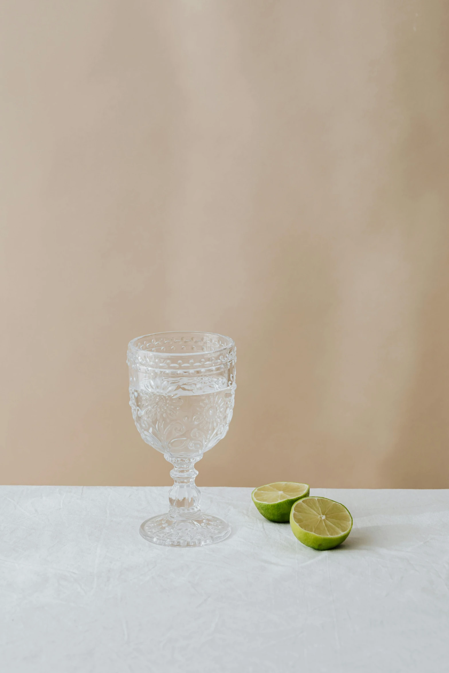 a small glass is sitting beside a lime on a table