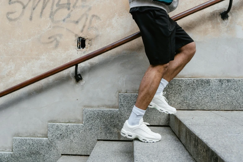 man standing at the bottom of steps on his skateboard