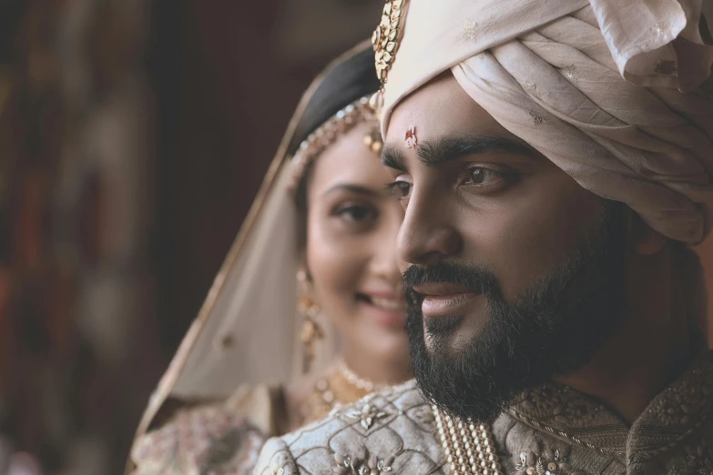 a man wearing a white turban and a woman wearing a red dress