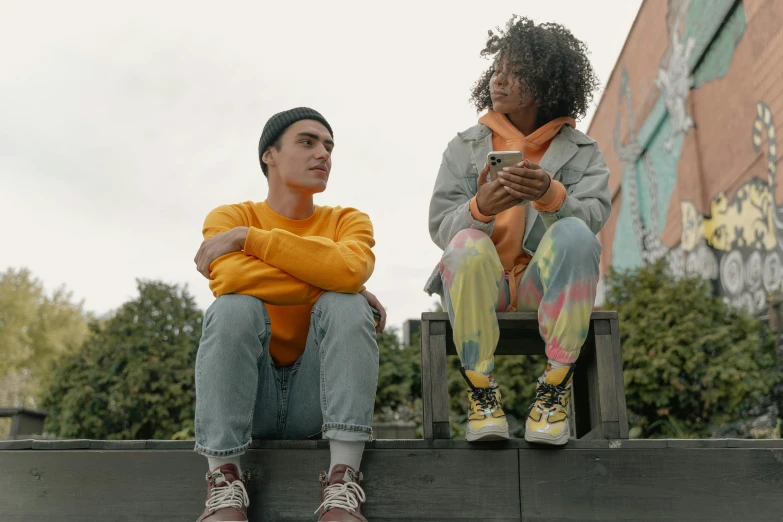 two women with their arms crossed sitting on benches