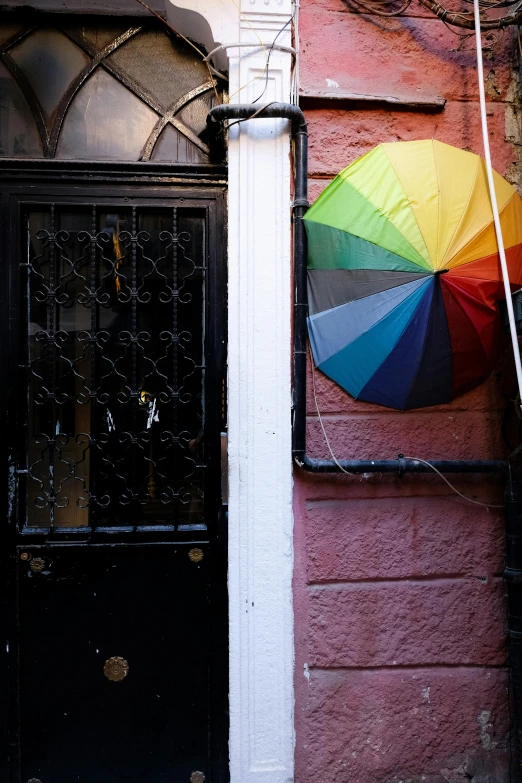 a rainbow umbrella is hanging outside of a building