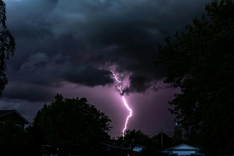 a lightning bolt is seen in the sky above houses