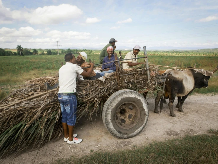 several people that are sitting on a wooden wagon