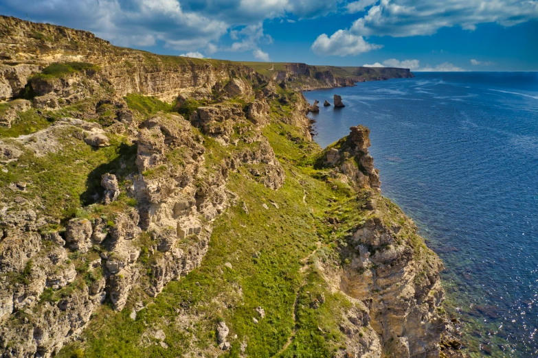 an open sea with mountains and grass along it