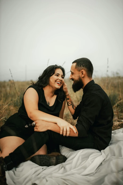 the man and woman are sitting on the bed smiling