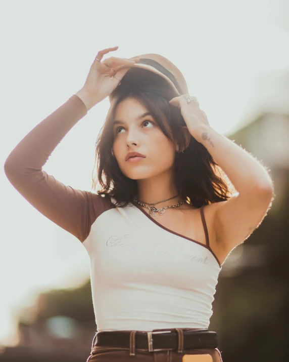 a woman wearing brown pants standing in front of the sun