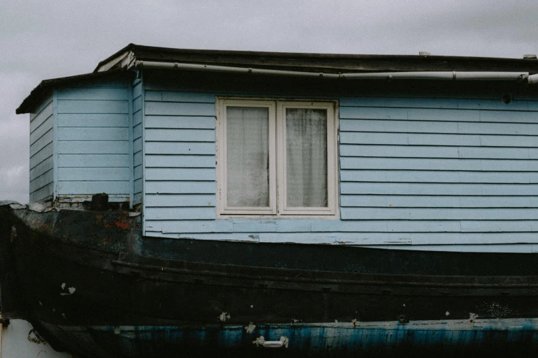 blue house next to a black boat in the water