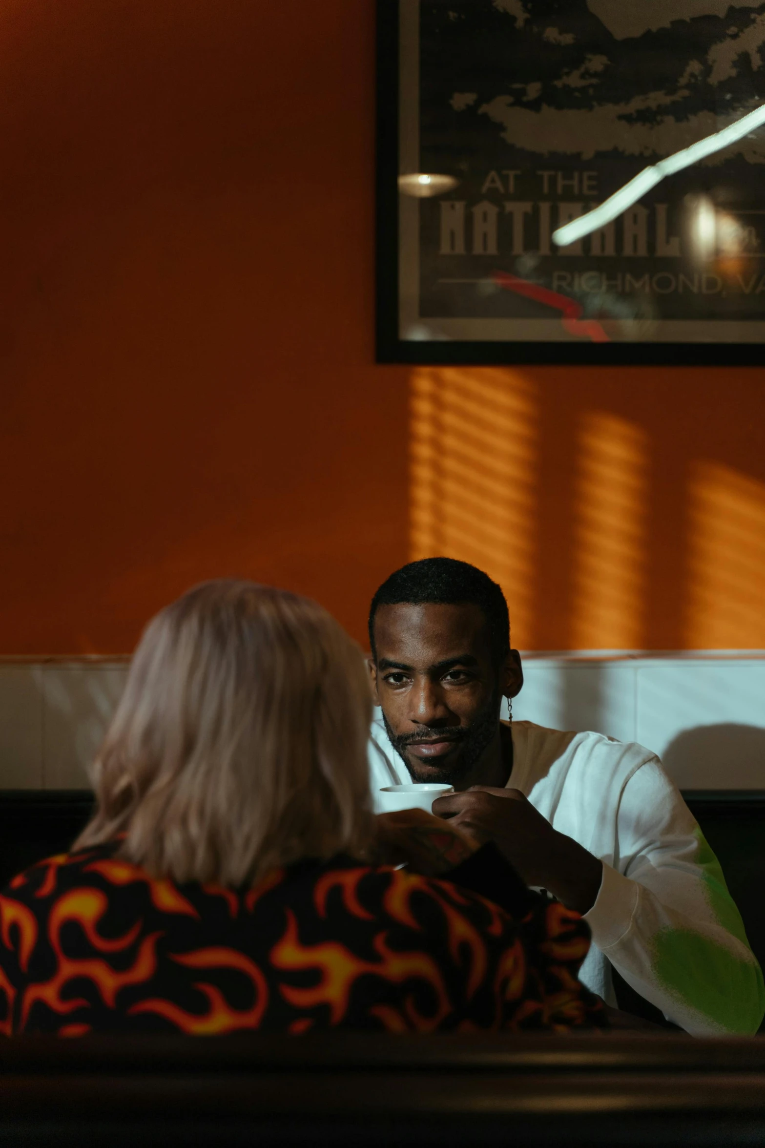 a man sitting at a table looking at the woman