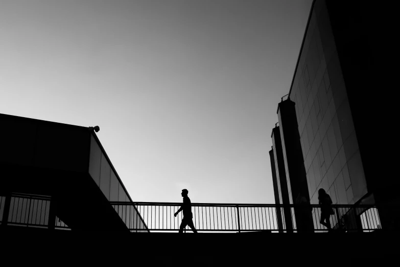 a person walking over a bridge near tall buildings