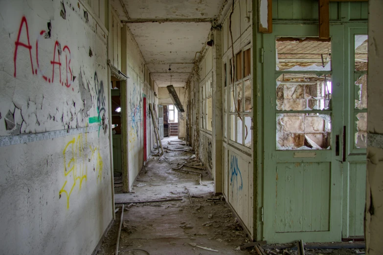 an old hallway with doors and walls covered in graffiti