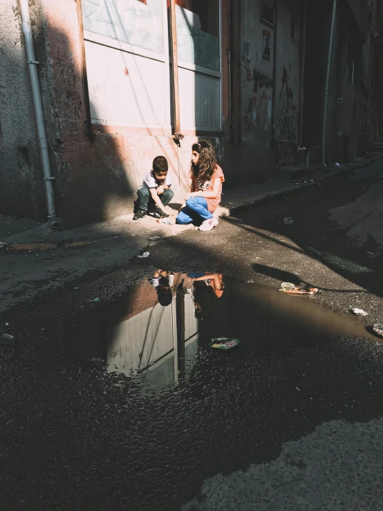 two people sitting by a dle, while the light is streaming through the building