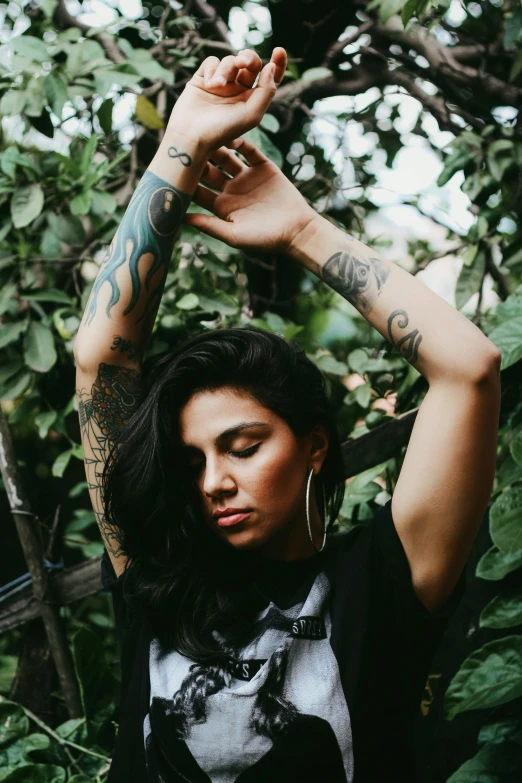 a woman with tattoos holding up her arm