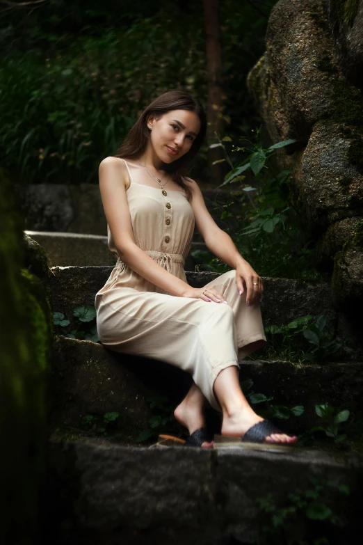 a woman is sitting on a stone step and smiling