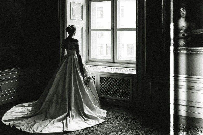 a beautiful wedding dress hanging on a window sill