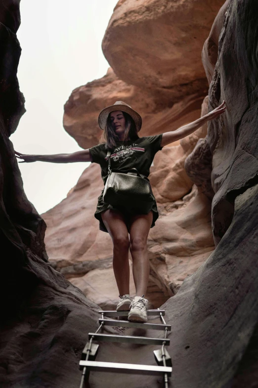 a woman climbing a ladder in a canyon