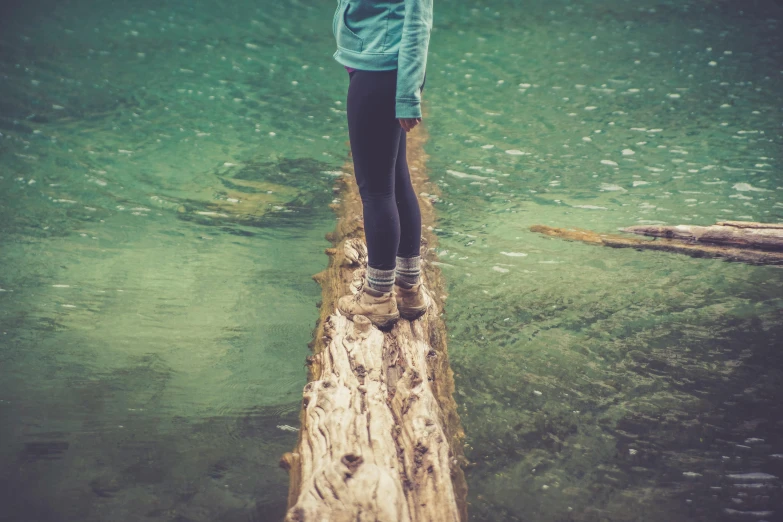 a person standing on a log in the water