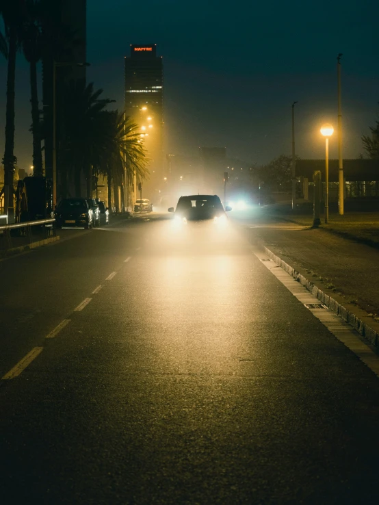 cars are driving down the road in the dark