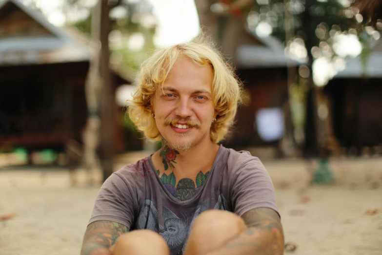 a man is looking straight ahead while sitting on the ground