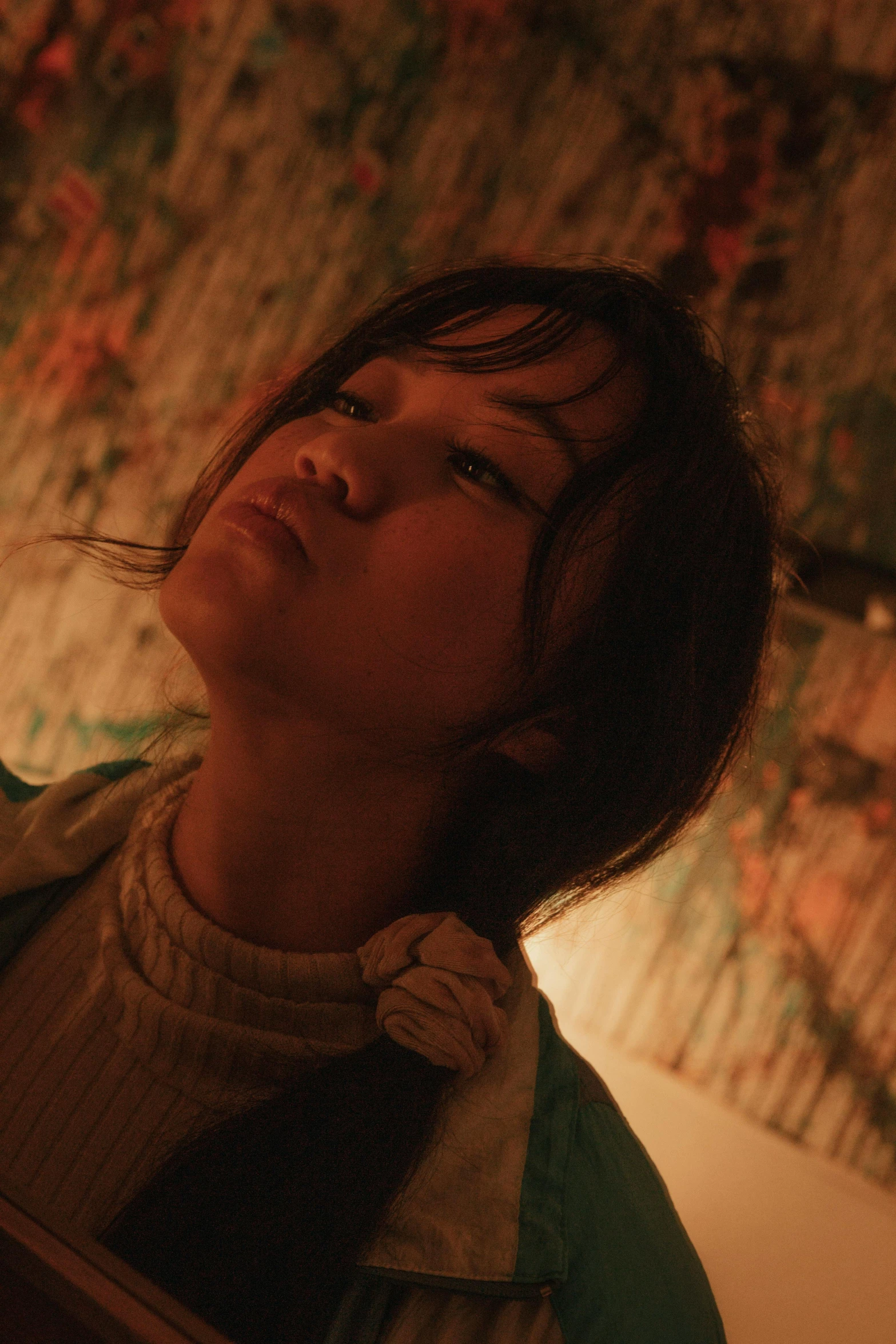 a woman with brown hair is in profile and looking up at a wall