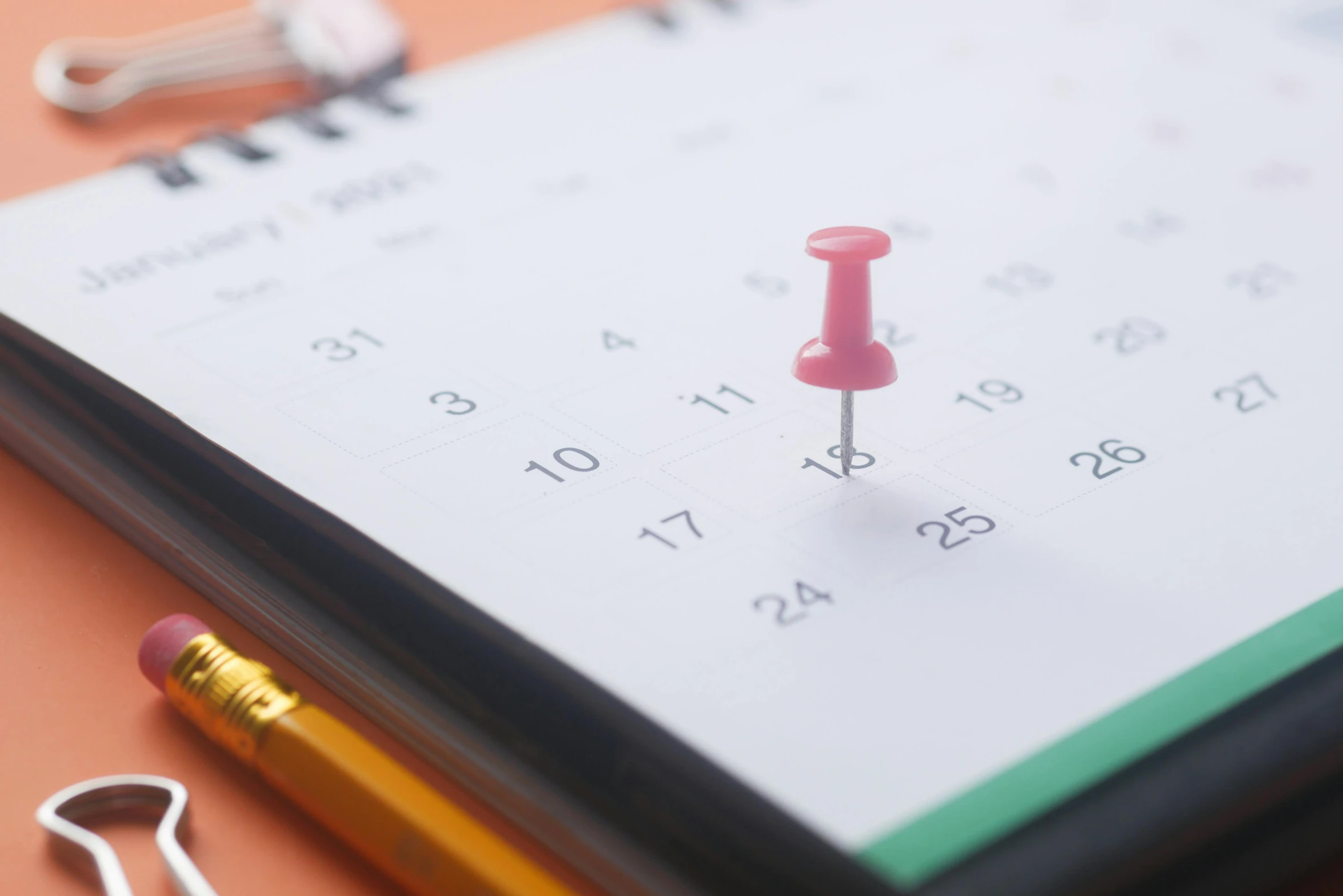 a pencil and a thumb stick are on top of a calendar